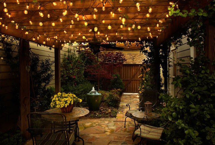 Patio lit by string lights on pergola